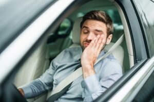 man with low energy driving a car